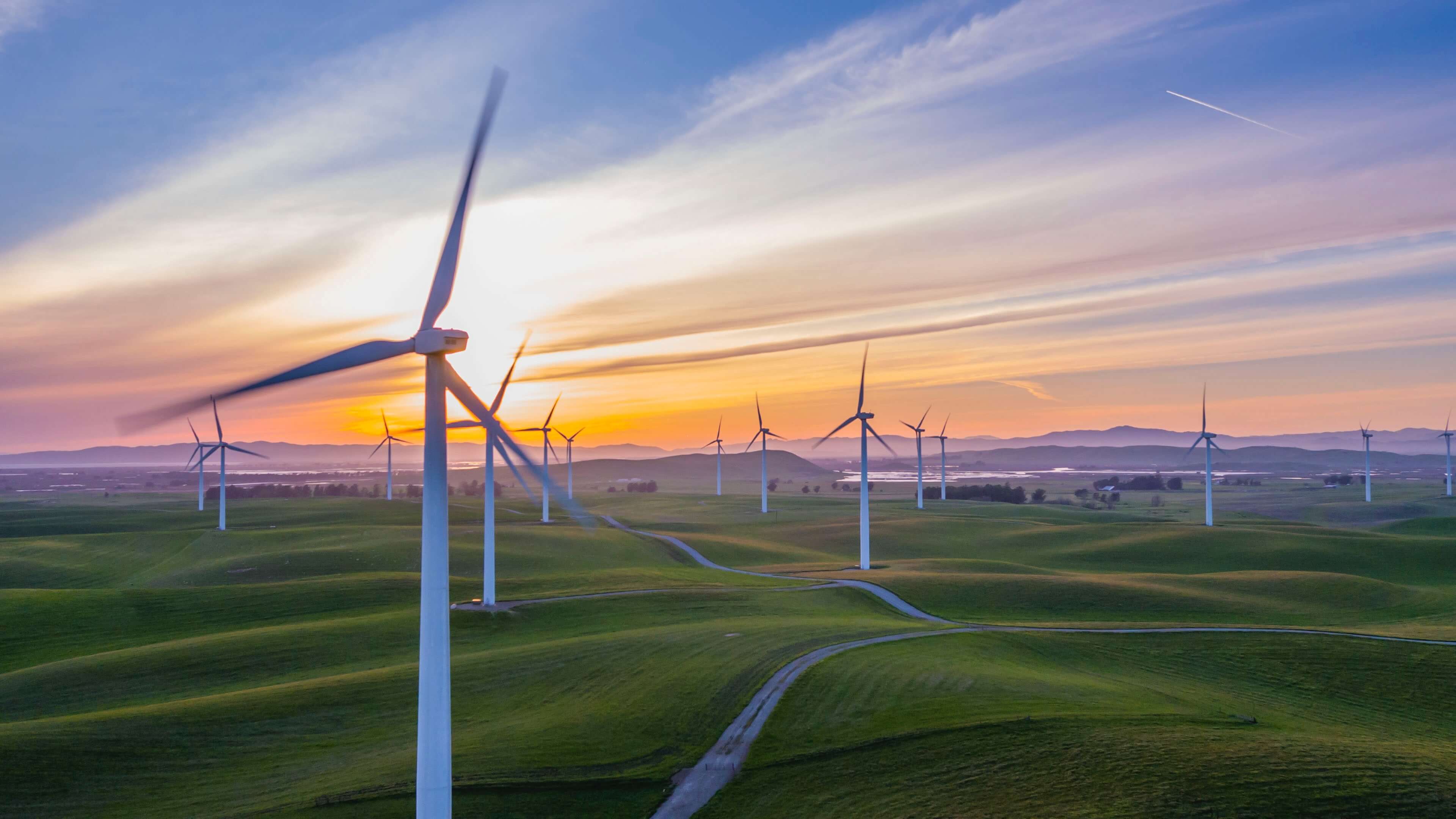 White windmills against a colorful sky